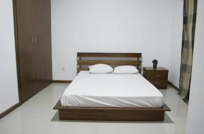 a bedroom with a bed with two pillows on it at T1 conforto in Praia