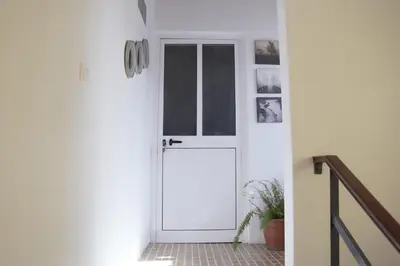 a white door in a hallway with a plant at T1 conforto in Praia