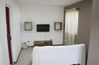 a white room with a television and a table at T1 conforto in Praia