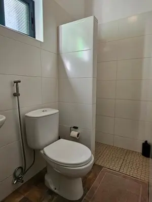 a bathroom with a white toilet and a window at Casa Medina in Fajãzinha