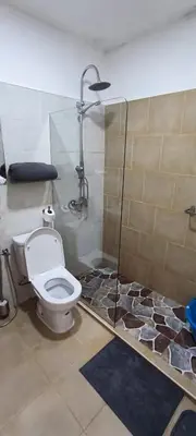 a bathroom with a toilet and a glass shower at Casas do Cinema II in Mindelo