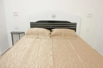 a bed with a brown comforter and two pillows at WEYt1 in Sal Rei