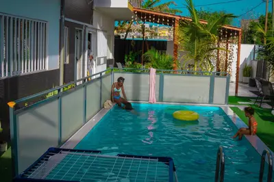 two women sitting in a swimming pool with a frisbee at Hotel Xinte na casa in Tarrafal