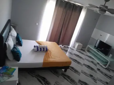 a room with a bed and a television in a room at Hotel Xinte na casa in Tarrafal