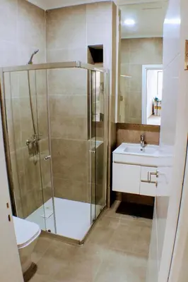 a bathroom with a shower and a toilet and a sink at ACG Plato Vacation Apartment with Balcony in Praia