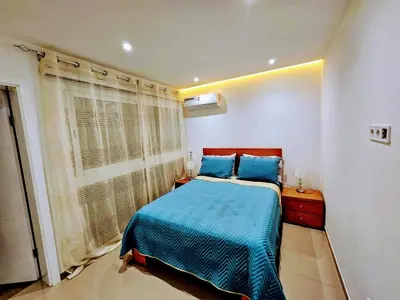 a bedroom with a blue bed and a window at ACG Plato Terrace & Balcony Apartments in Praia