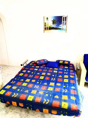 a bed with a colorful comforter in a bedroom at Feeling Cabo Verde in Beirona