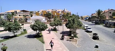 a city street with trees and people walking on the sidewalk at Residencial Ilha do Maio App 101 in Santa Maria