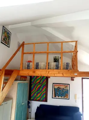 a loft bed in a room with a blue couch at Residencial Ilha do Fogo app 205 in Santa Maria
