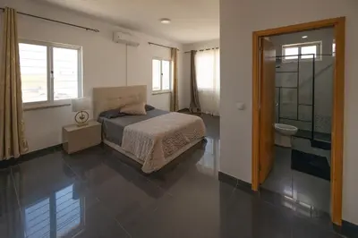 a bedroom with a bed and a bathroom at Villa RESIDENCIAL EUNICE in Praia