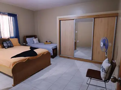 a bedroom with a bed and a chair and a mirror at Pensão Dona Fica in Tarrafal