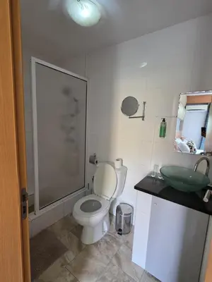 a bathroom with a toilet and a green sink at Djeu View in Praia