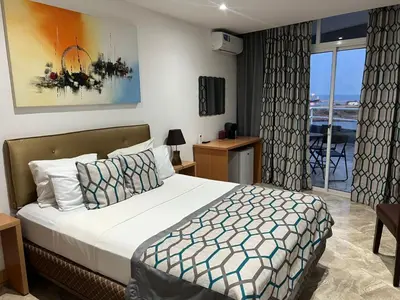 a hotel room with a bed and a balcony at Djeu View in Praia
