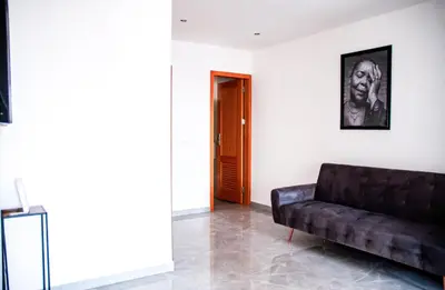 a living room with a black couch and a picture at Brand new apartment in Mindelo in Mindelo