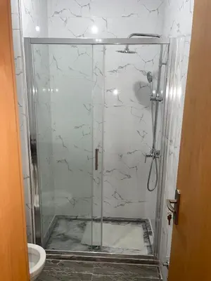 a shower with a glass door in a bathroom at madison place in Praia