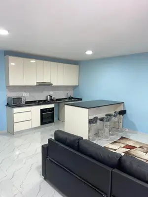 a living room with a couch and a kitchen at madison place in Praia