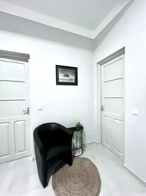 a black chair in a room with two doors at MorabezaHome- Apartment Tati in Mindelo
