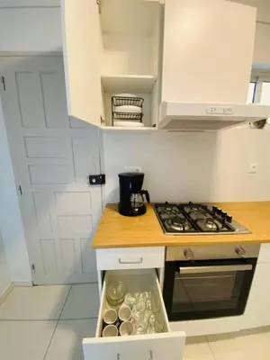 a kitchen with white cabinets and a stove top oven at MorabezaHome- Apartment Tati in Mindelo