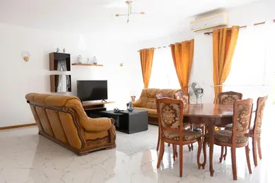 a living room with a dining room table and chairs at 2 bdr apt in Palmarejo Baixo, near seafront - LCGR in Praia