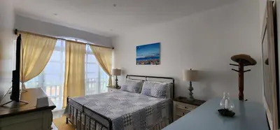 a bedroom with a bed and a large window at Casinha Nova - Comfort & Class in Fogo in São Filipe