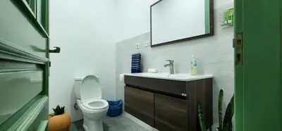 a bathroom with a toilet and a sink and a mirror at Casinha Nova - Comfort & Class in Fogo in São Filipe