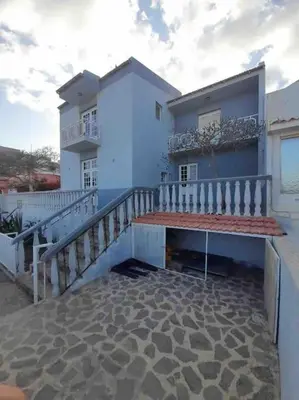 a blue house with a balcony and a balcony at Vivenda com pátio, no coração do Mindelo in Mindelo