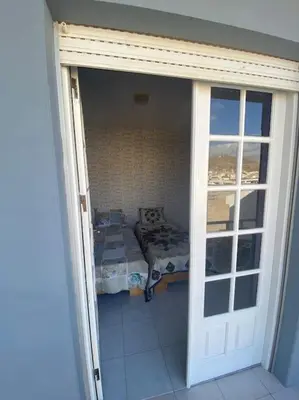 an open door to a room with a bed at Vivenda com pátio, no coração do Mindelo in Mindelo