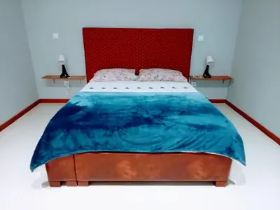 a bedroom with a large bed with a red headboard at Niclas ApartamentoT1 in Praia