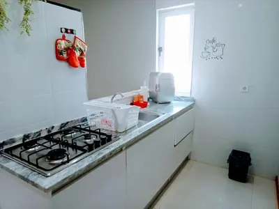 a white kitchen with a stove and a sink at Niclas ApartamentoT1 in Praia