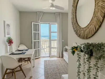 a living room with a white table and a mirror at Papaya Apartments Boa Vista in Sal Rei