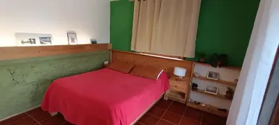 a bedroom with a red bed and green walls at Casa Cavoquinho in Paul