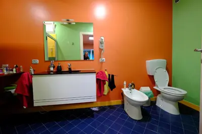 a bathroom with a toilet and a sink and a mirror at Casa Comba in Mindelo