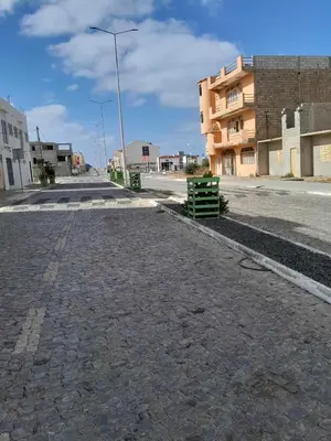 an empty street with a building and a street light at Apto Martins - Prédio Residencial Inês nº23 in Vila do Maio