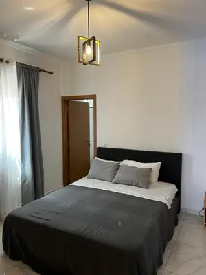 a bedroom with a large bed with a black blanket at Pensão Gonçalves in Calheta de São Miguel