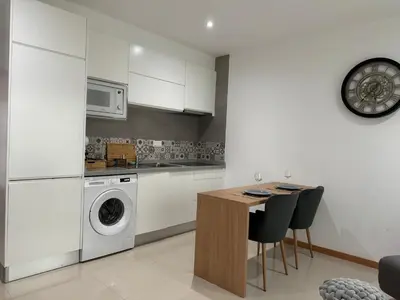a kitchen with a washing machine and a table with chairs at SMR AP08 in Santa Maria