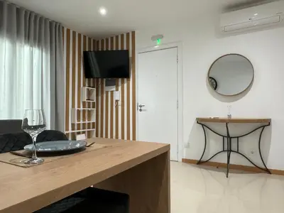 a living room with a table and a mirror at SMR AP08 in Santa Maria