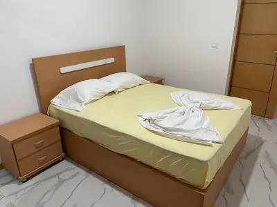 a bed with yellow sheets and a wooden headboard at Rosario’s Residence in Praia