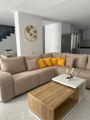 a living room with a brown couch and a coffee table at Rosario’s Residence in Praia