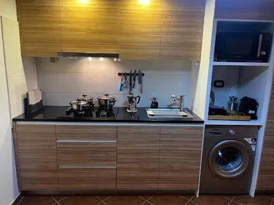 a kitchen with a stove and a washing machine at Beira Mar AB2 in Santa Maria