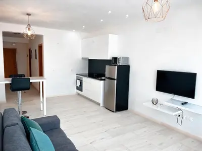 a living room with a couch and a kitchen at P&SApartments in Santa Maria