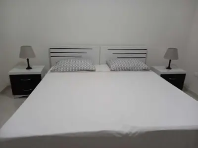 a bedroom with a large white bed with two night stands at Black Diamond - CASA Tia Bia in Ribeira Grande