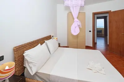 a bedroom with a large white bed with towels on it at T1 Vista Mar - Porto Antigo 3 in Santa Maria
