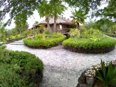 a stone path leading to a house in a garden at Casa De France in Porto Novo