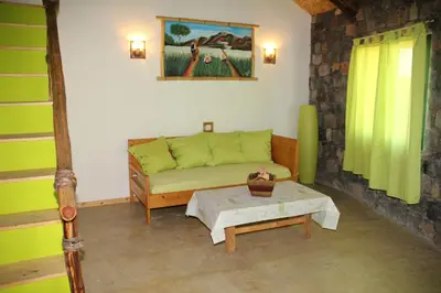 a living room with a green couch and a table at Casa De France in Porto Novo