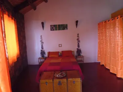 a bedroom with a bed with a table and a bed sidx sidx sidx at Casa De France in Porto Novo
