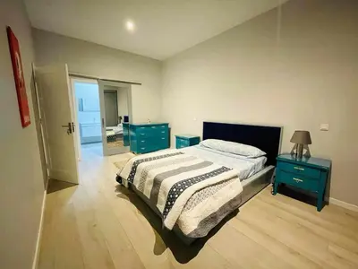 a bedroom with a bed and two blue night stands at Aparthotel Pilon T3 in Praia