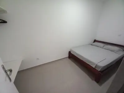 a small bed in a room with a white wall at SILVAs Apartment in Mindelo