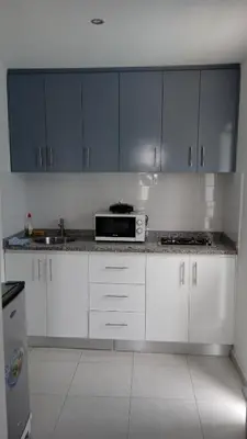 a kitchen with white cabinets and a microwave at CasaMrichica1 in Ribeira Grande