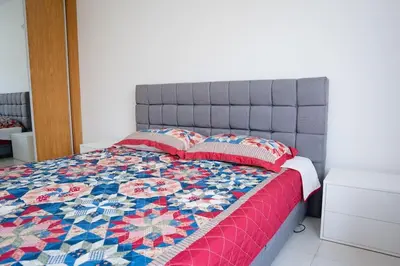 a bed with a quilt and pillows on it at Apartamento das Flores 2 in Praia