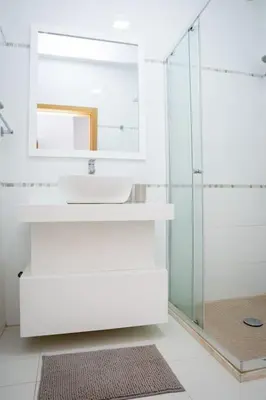 a bathroom with a sink and a glass shower at Apartamento das Flores 2 in Praia